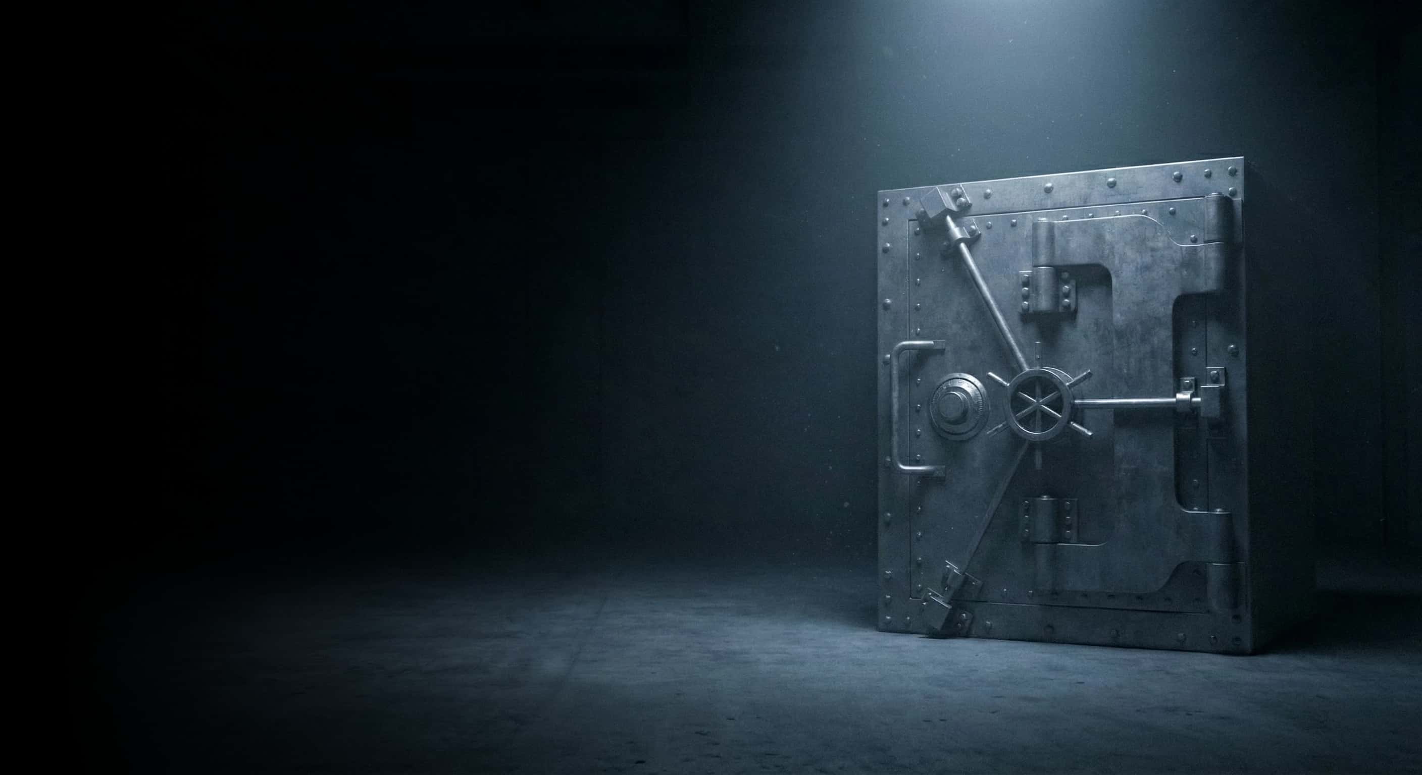 A large, impenetrable safe in a dark room, illuminated by a single spotlight